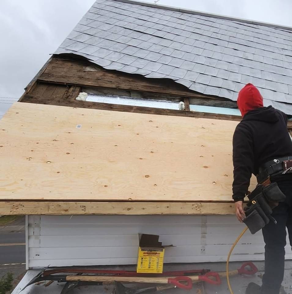 Un homme au chapeau rouge travaille sur un toit
