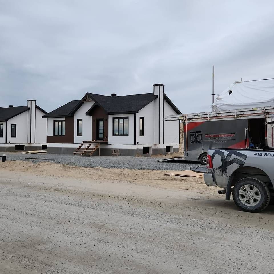 Un camion blanc est garé devant une rangée de maisons