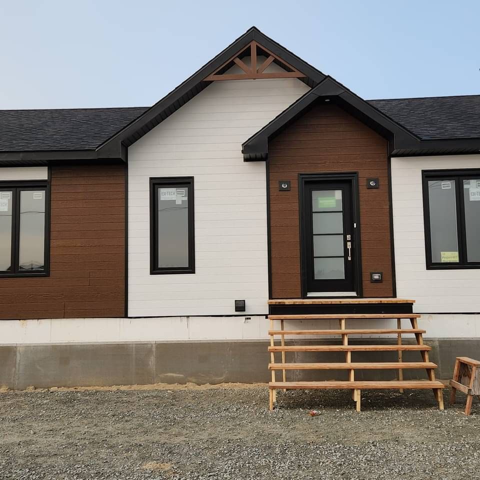Une maison blanche et marron avec des escaliers menant à la porte d'entrée