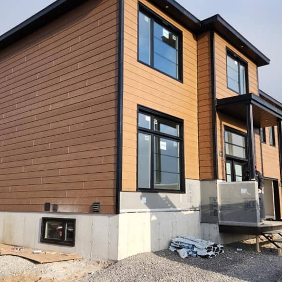 Une maison avec beaucoup de fenêtres est en construction