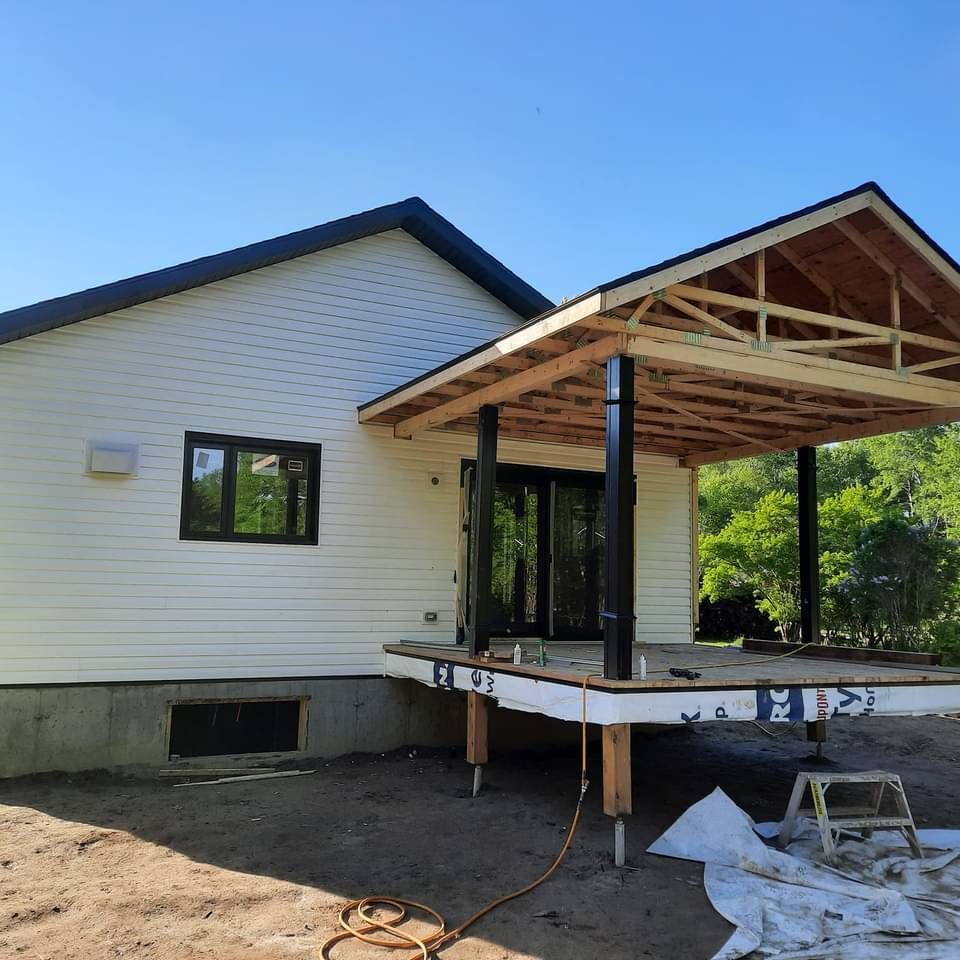 Une maison blanche au toit noir est en construction