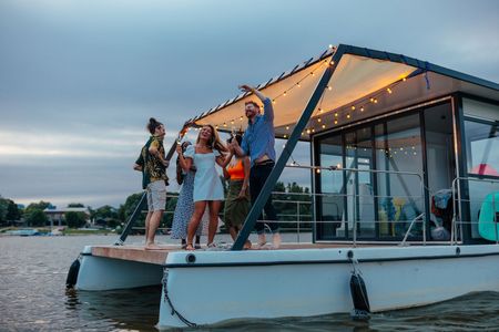 A group of people are dancing on a boat in the water. A group of people are dancing on a boat in the water.