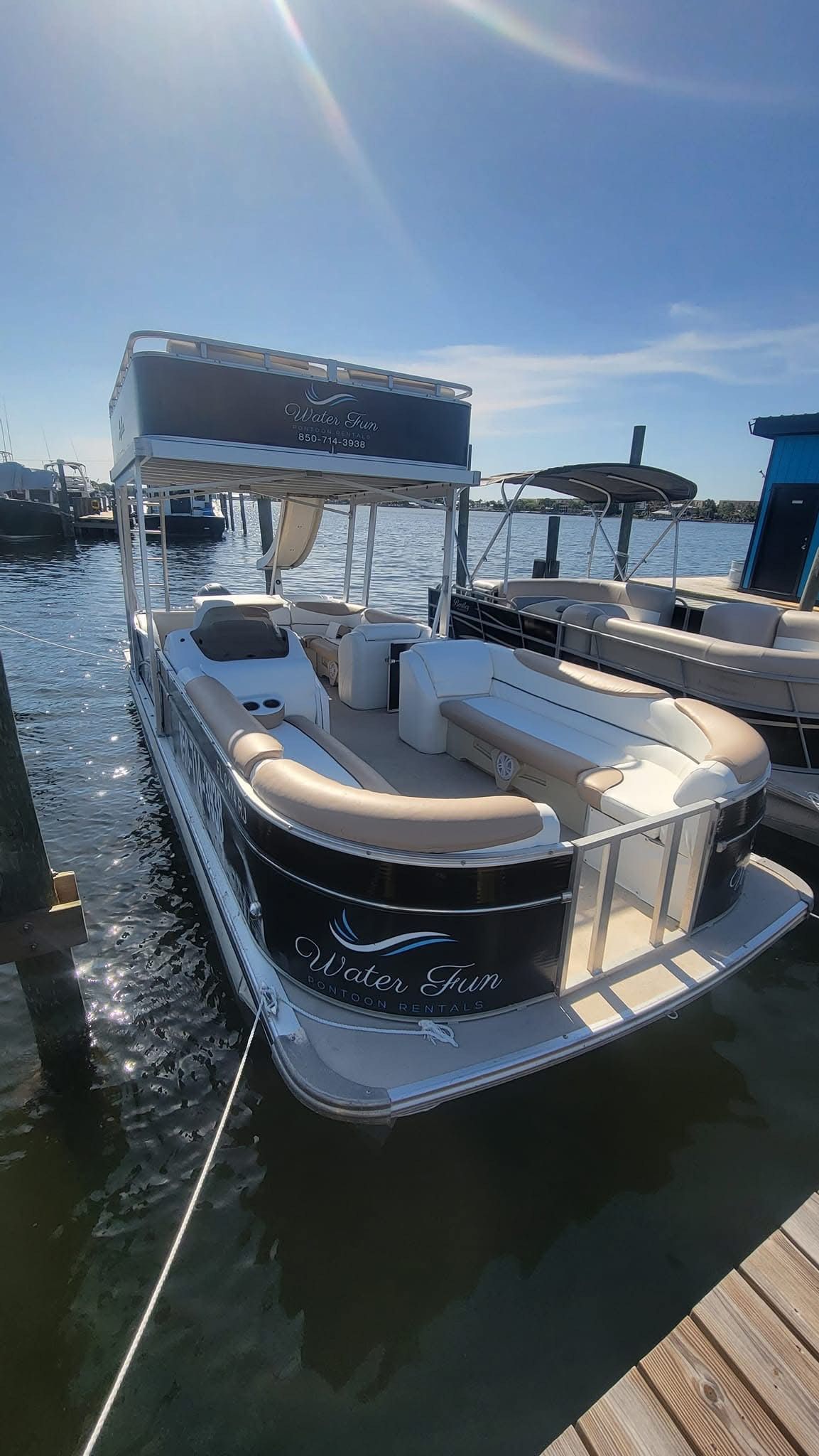 A pontoon boat is docked at a dock in the water.