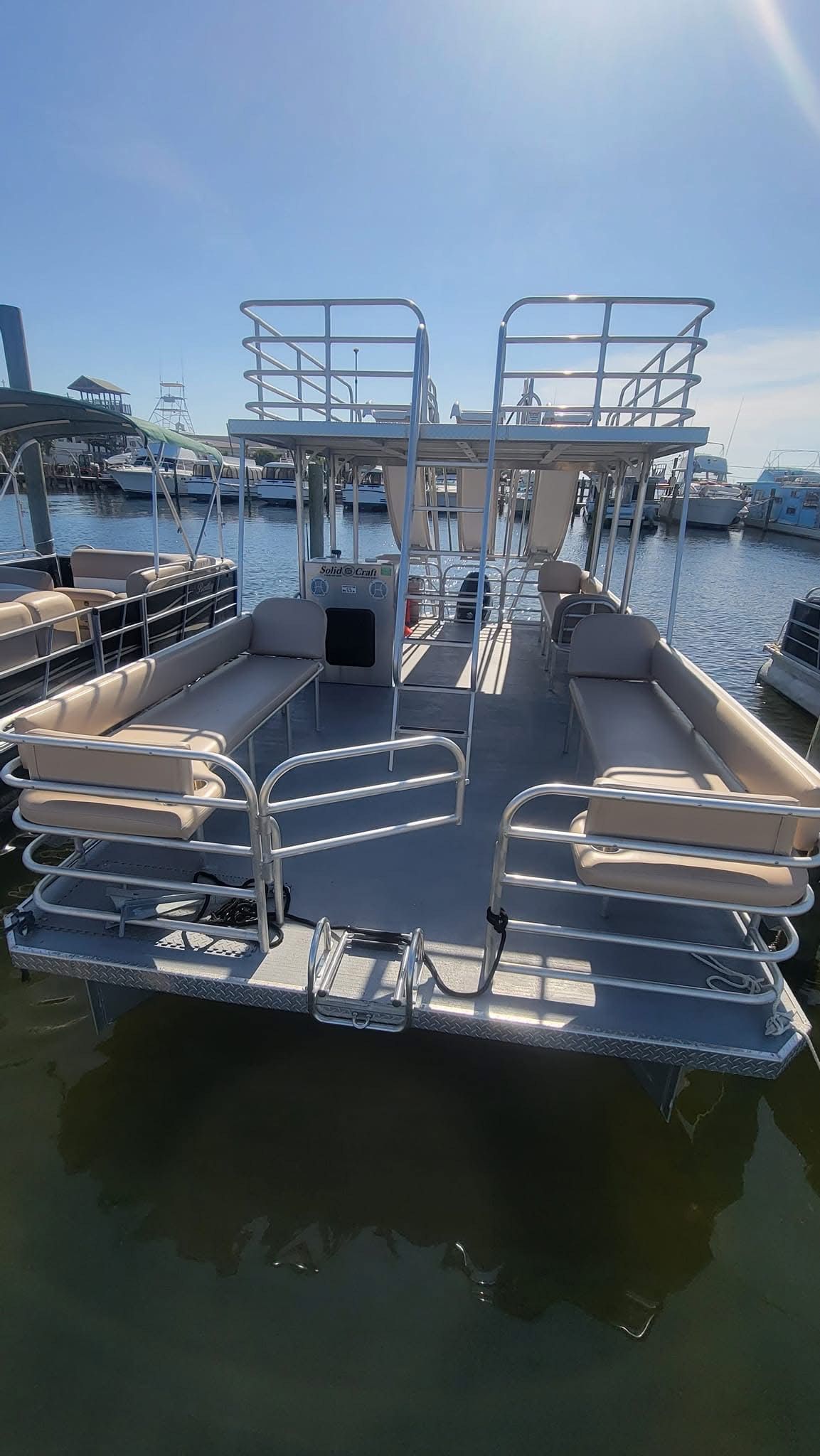 A pontoon boat is docked in a marina.
