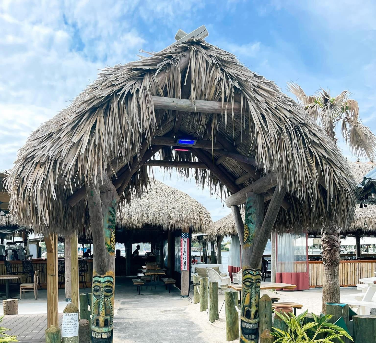 A hut with a thatched roof is surrounded by palm trees A hut with a thatched roof is surrounded by palm trees