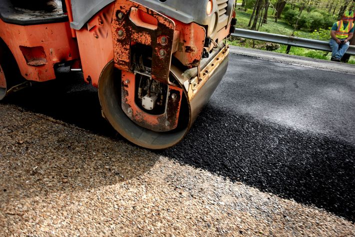 A roller is rolling asphalt on a road