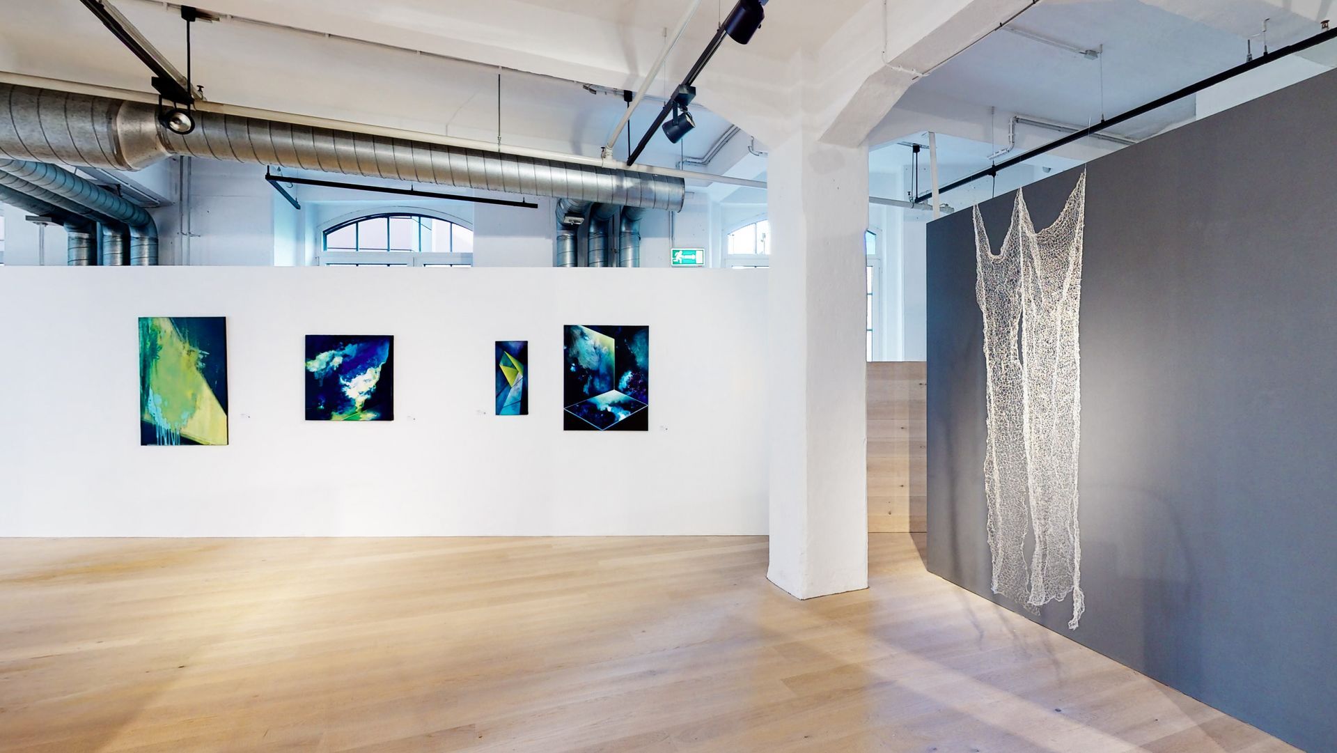 Ausstellungsansicht mit Gemälden und einer Skulptur