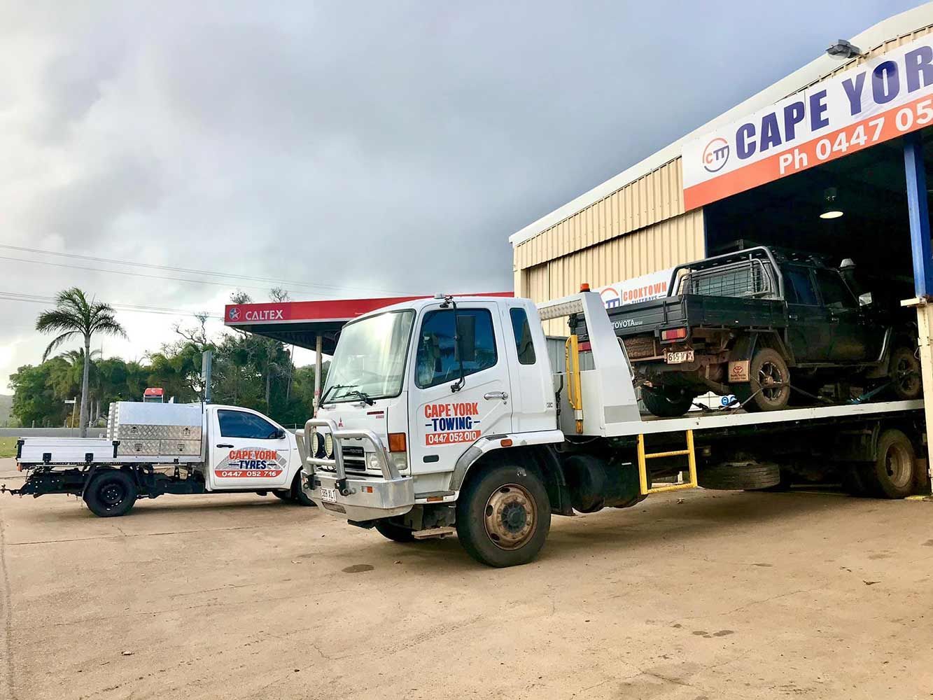Two Tow Trucks Are Parked in Front of a Building — Cape York Towing & Transport in Lockhart River, QLD
