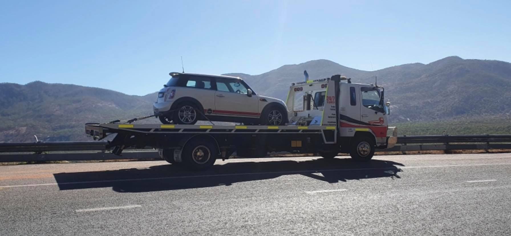 Two Cars Are Being Towed by a Tow Truck on a Dirt Road — Cape York Towing & Transport in Archer River, QLD
