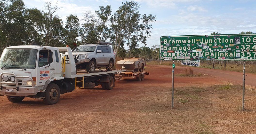 Two Cars Are Being Towed by a Tow Truck on a Dirt Road — Cape York Towing & Transport in Coen, QLD