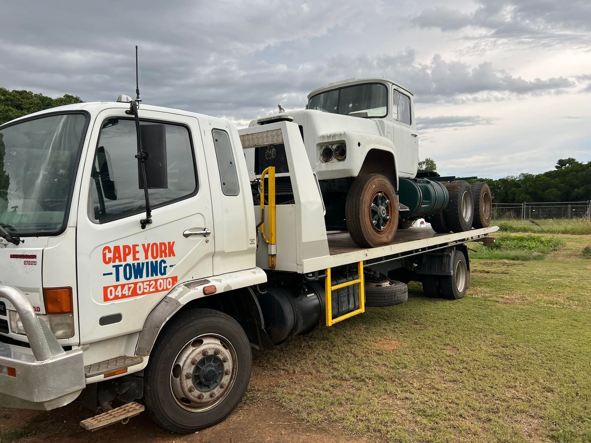 An Orange Car is Being Towed by a Tow Truck — Cape York Towing & Transport in Chillagoe, QLD