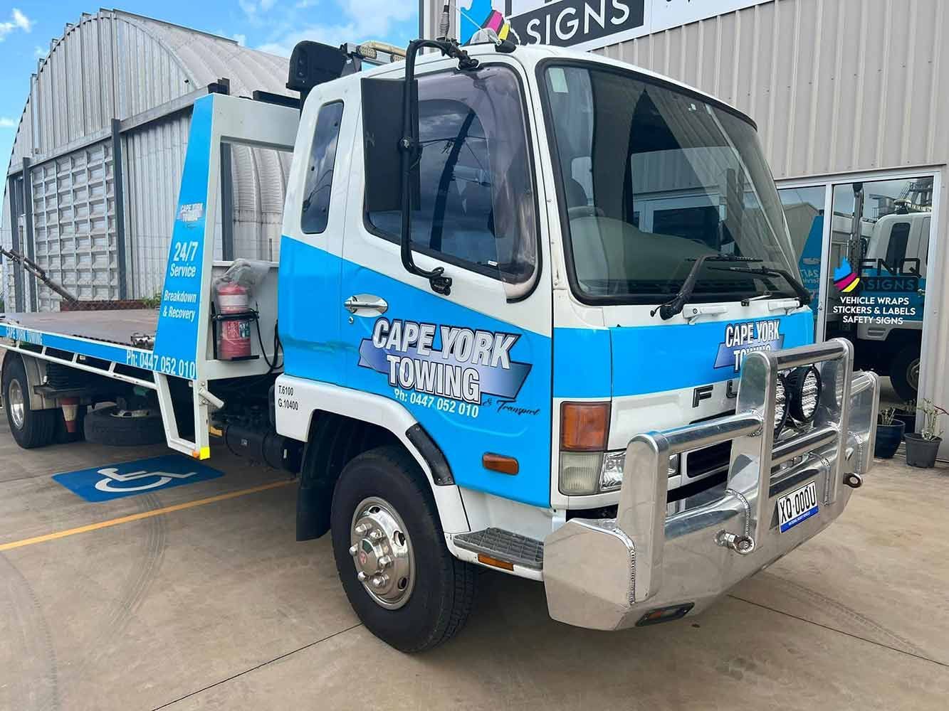 A Blue and White Tow Truck is Parked in Front of a Building — Cape York Towing & Transport in Cooktown, QLD