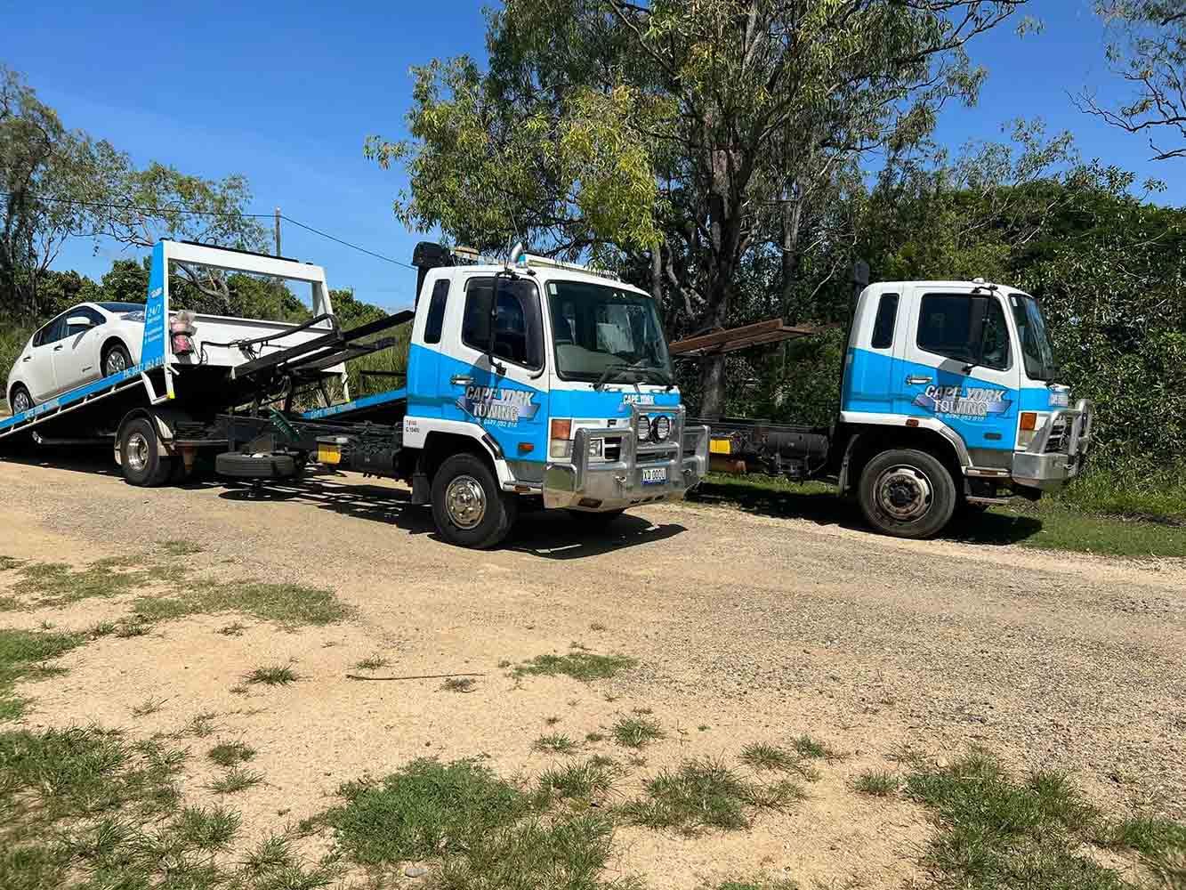 Two Tow Trucks Are Towing a Car on a Dirt Road — Cape York Towing & Transport in Weipa, QLD