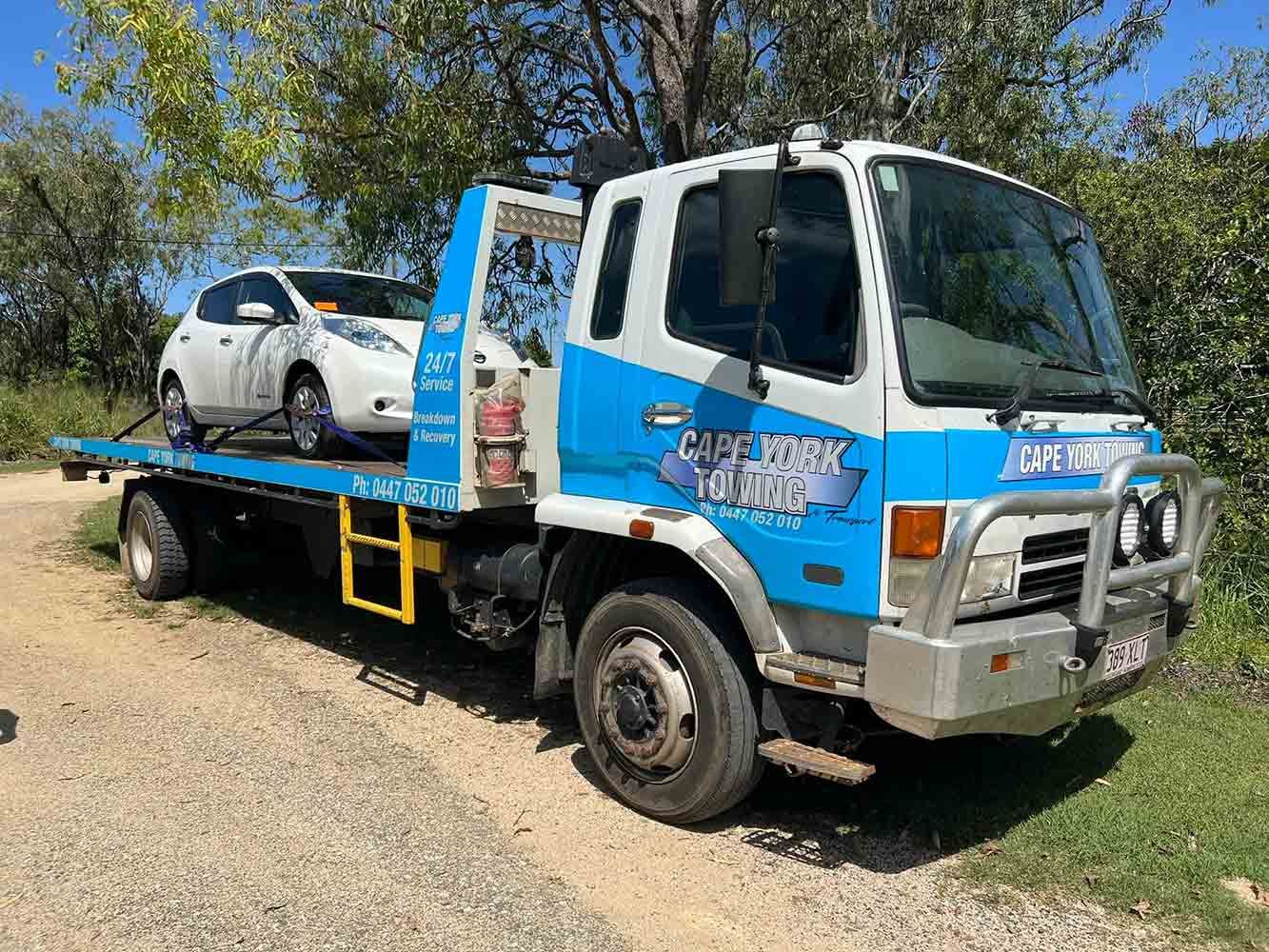 A Tow Truck With a Car on the Back is Parked on a Dirt Road — Cape York Towing & Transport in Adelaide, SA