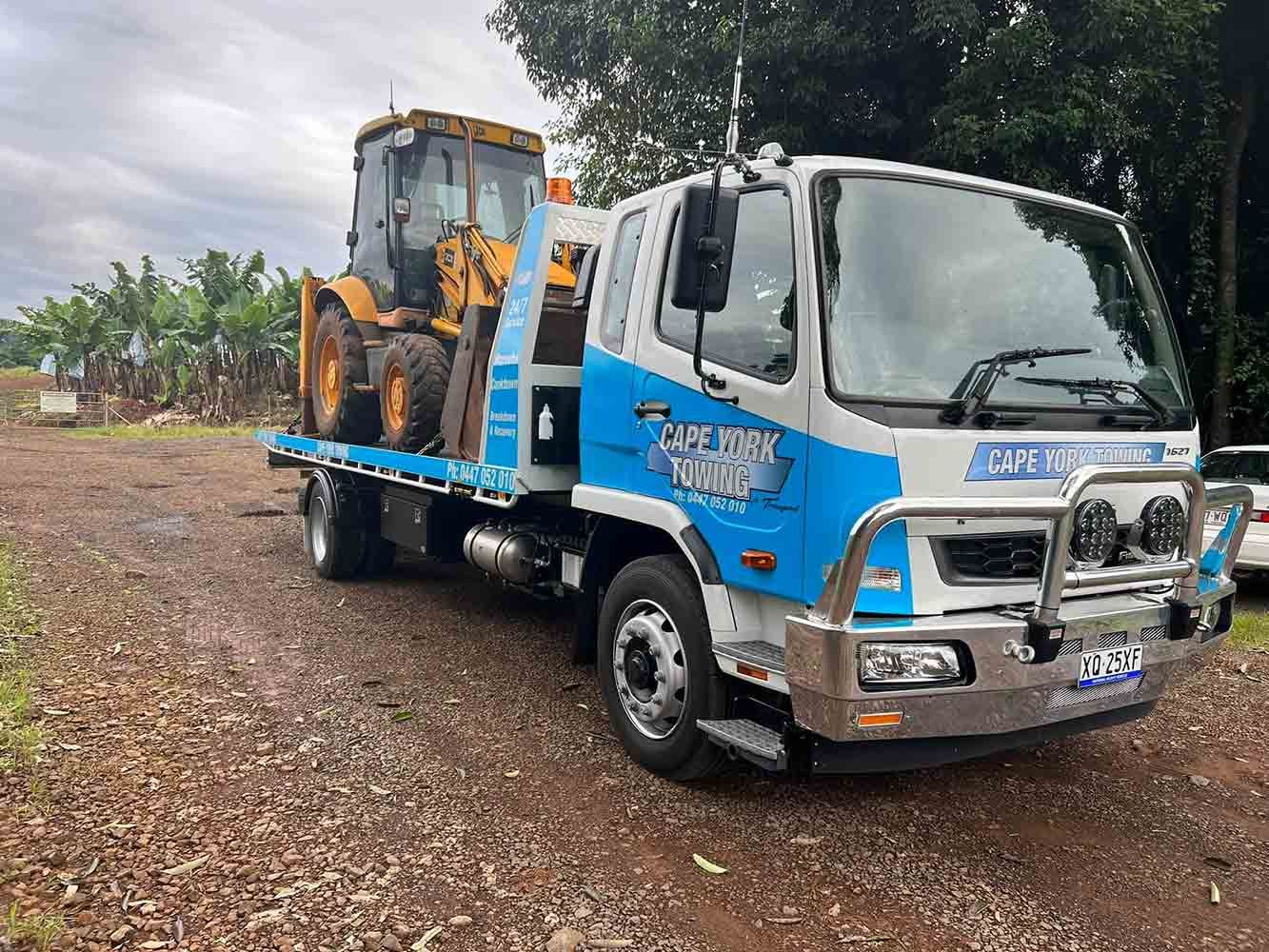 A Tow Truck is Carrying a Tractor on the Back of It — Cape York Towing in Hann River, QLD