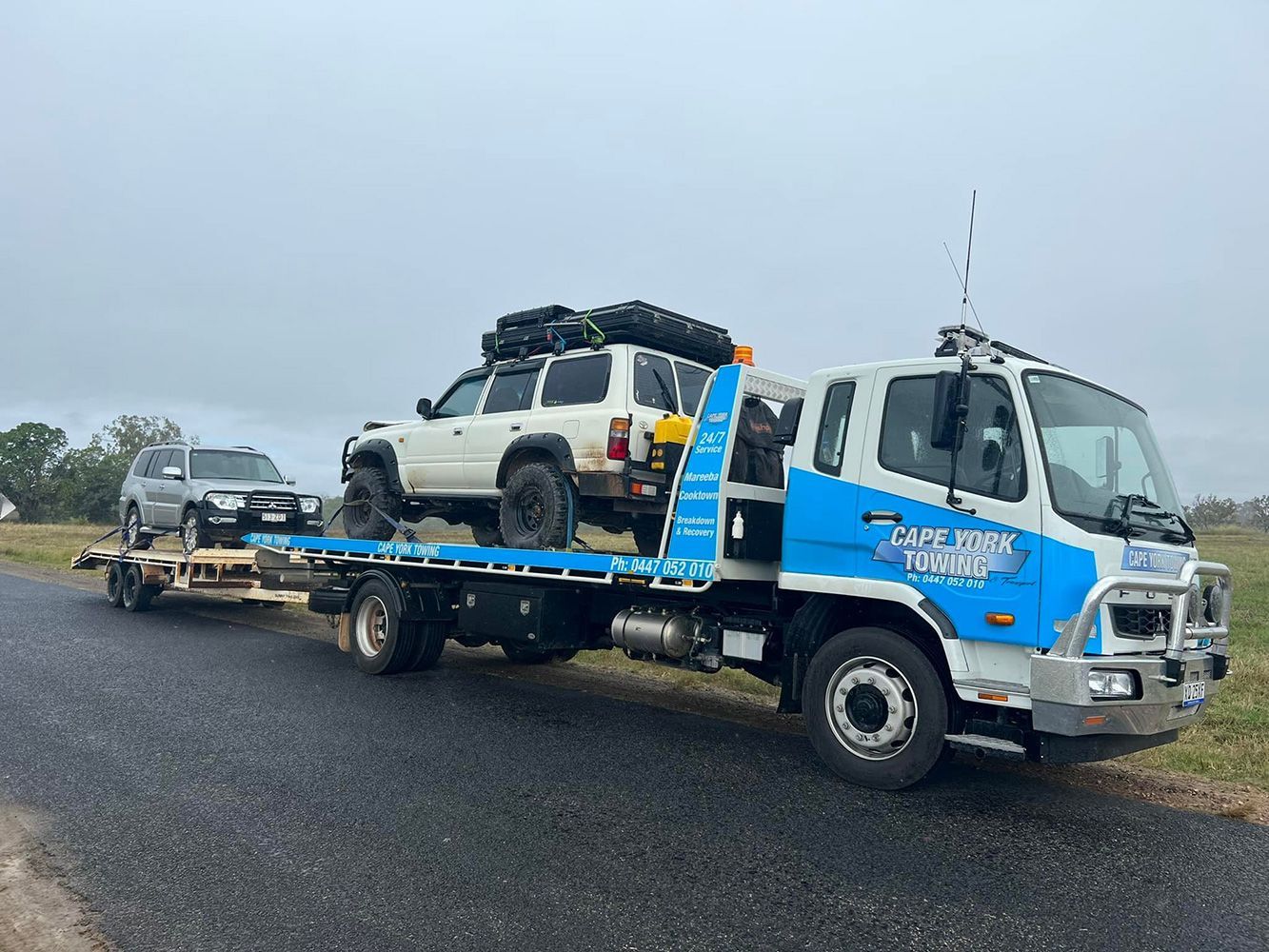 A Tow Truck is Carrying Two Cars on a Trailer — Cape York Towing & Transport in Mareeba, QLD