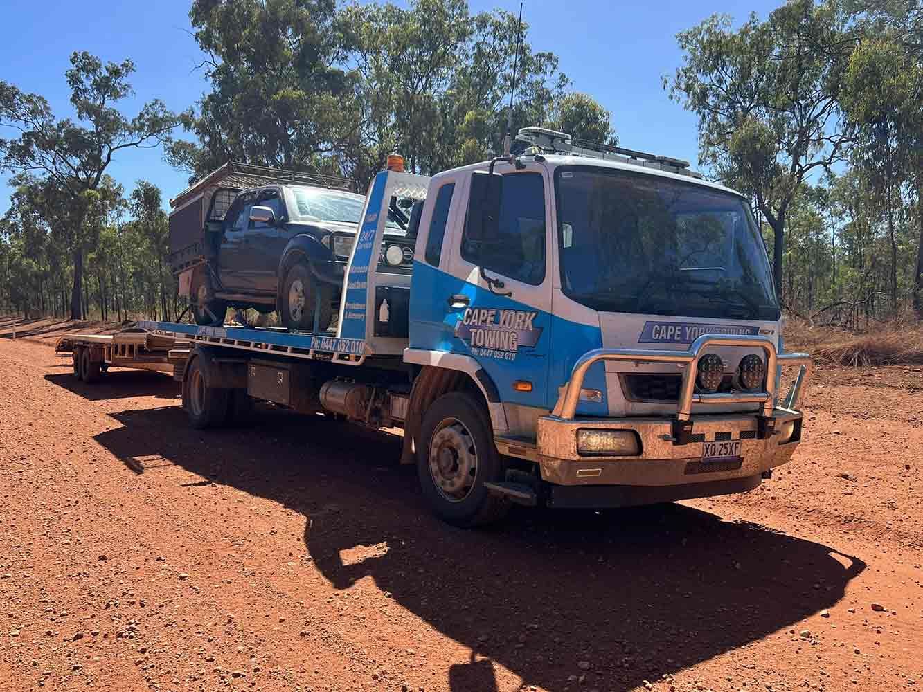 A Blue and White Tow Truck is Carrying a Car on a Trailer — Cape York Towing in Tablelands, QLD