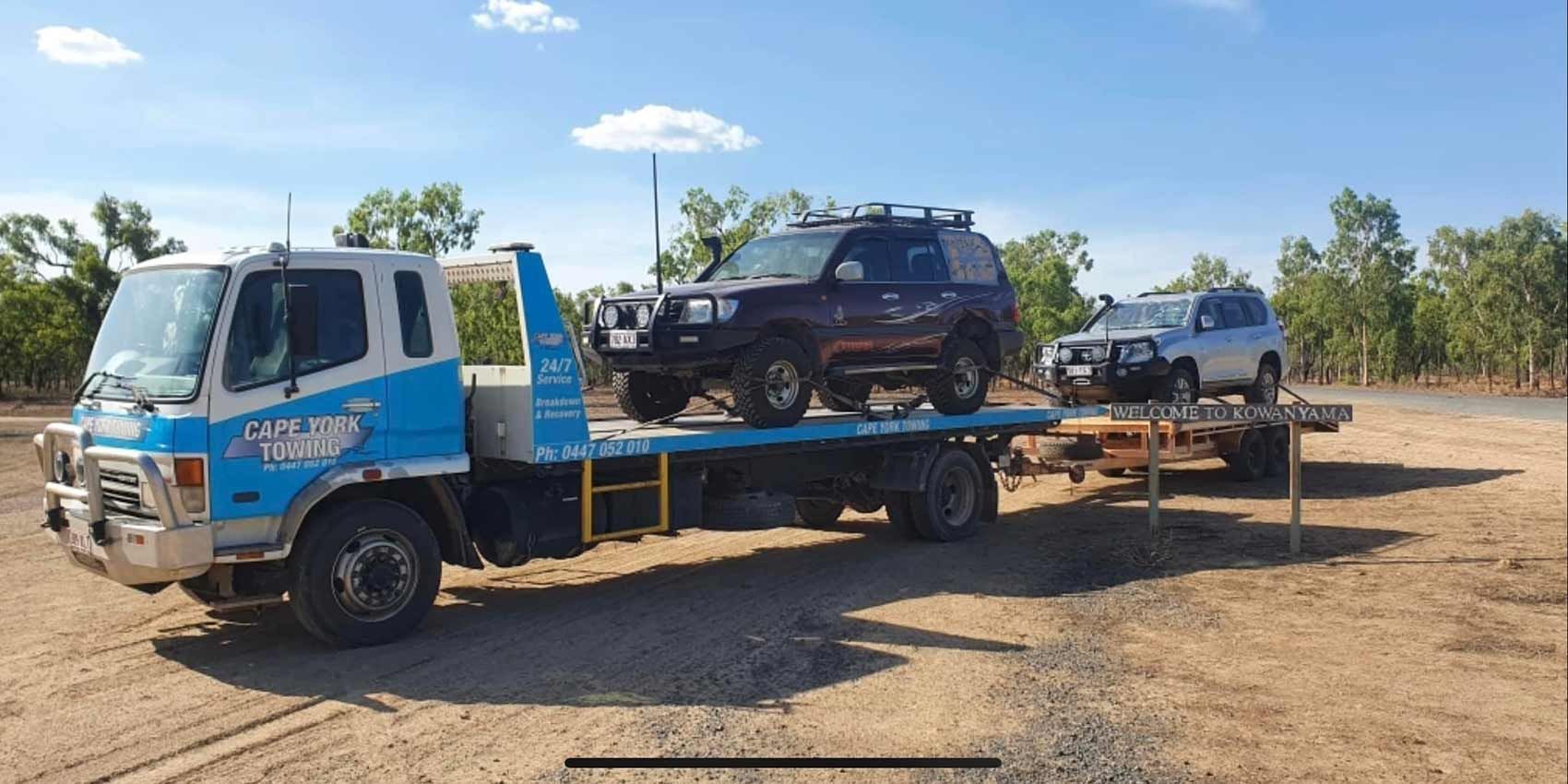 A Tow Truck is Carrying Two Cars on a Flatbed Trailer — Cape York Towing & Transport in Weipa, QLD