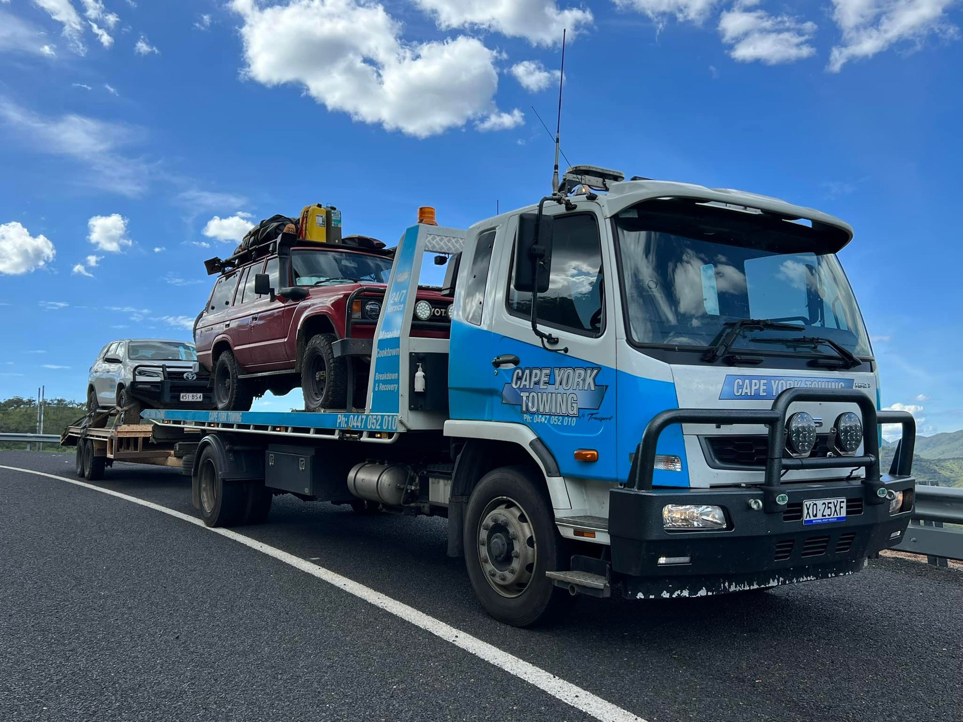An Orange Car is Being Towed by a Tow Truck — Cape York Towing & Transport in Brisbane, QLD