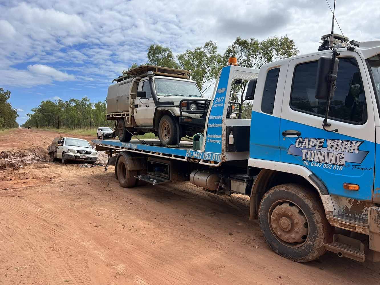 A Tow Truck is Towing a Car on a Dirt Road — Cape York Towing & Transport in Burketown, QLD