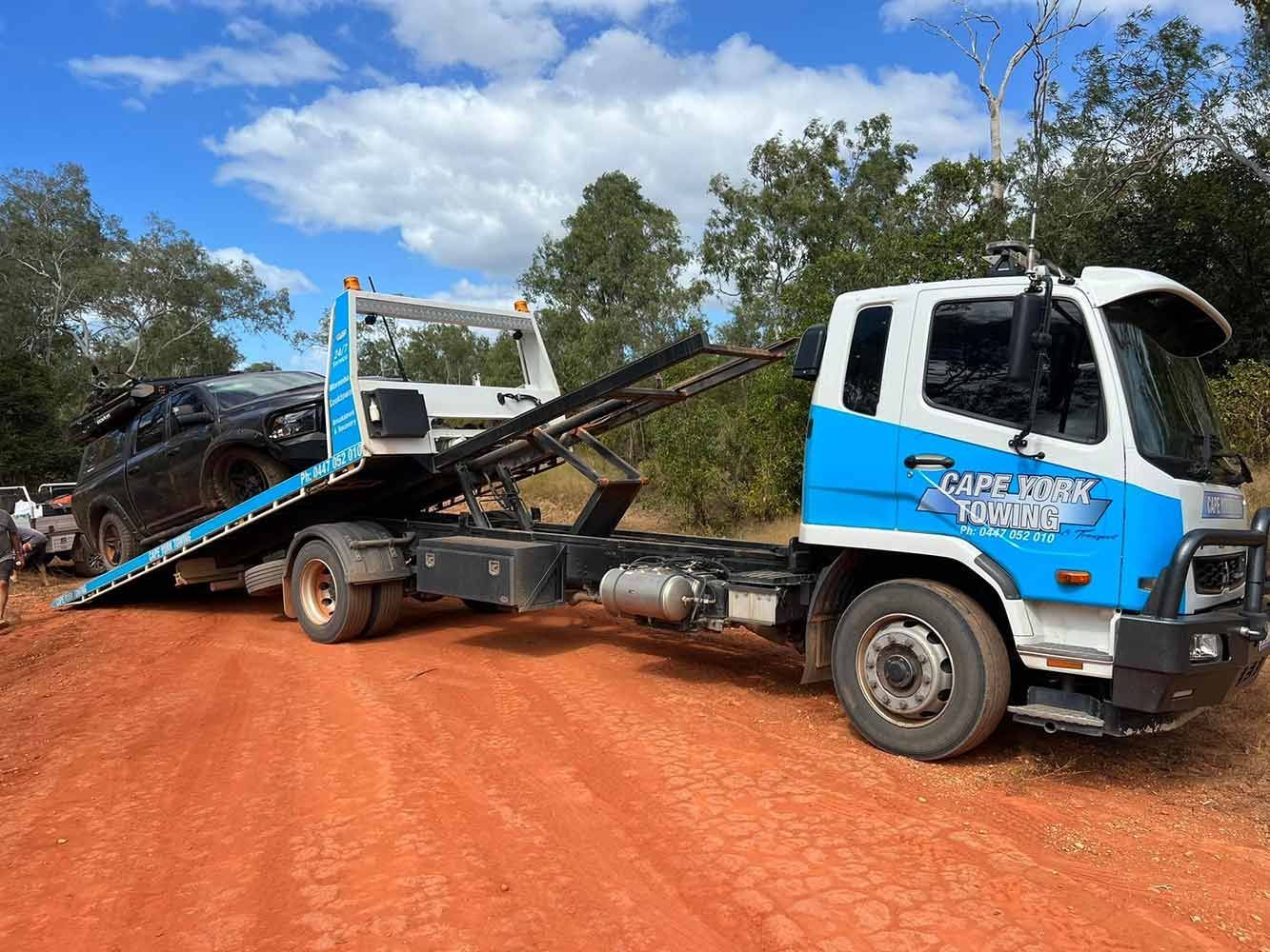 A Tow Truck is Towing a Car on a Dirt Road — Cape York Towing & Transport in Coen, QLD
