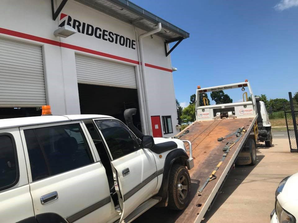 A White SUV is Being Towed by a Tow Truck — Cape York Towing & Transport in Lockhart River, QLD