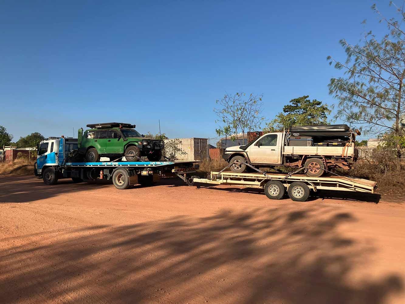 A Tow Truck is Carrying a Green Jeep and a White Truck — Cape York Towing in Bamaga, QLD