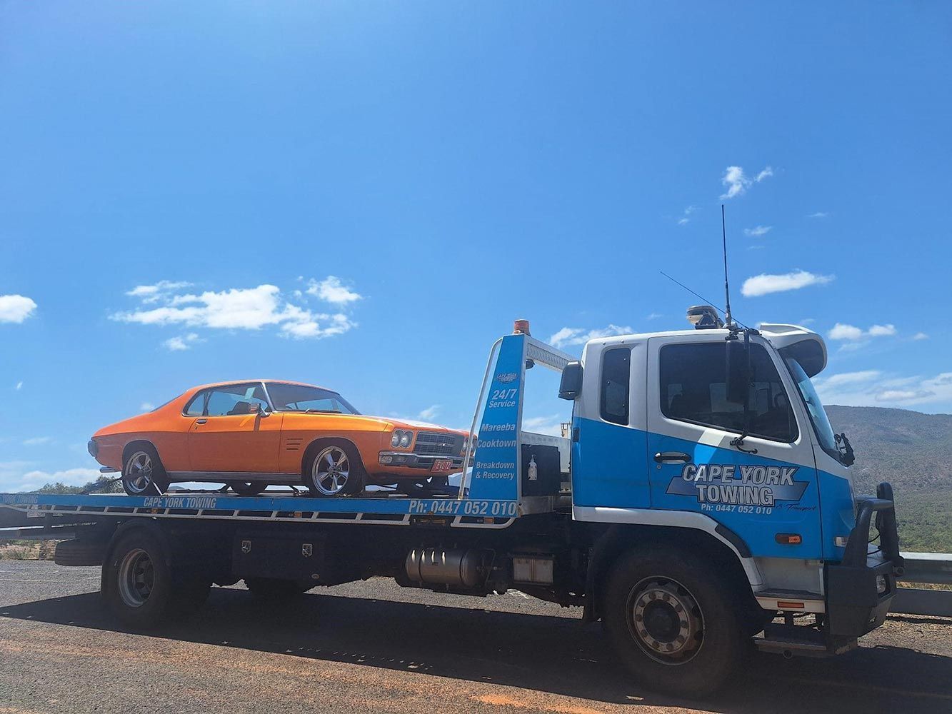 An Orange Car is Being Towed by a Tow Truck — Cape York Towing & Transport in Coen, QLD
