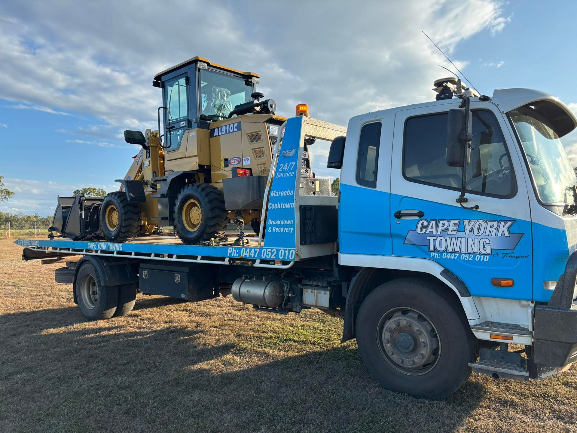 A Yellow Loader is Transported on a Flatbed Tow Truck With 