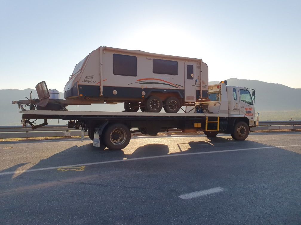 A Tow Truck is Driving Down a Dirt Road at Night — Cape York Towing & Transport in Archer River, QLD
