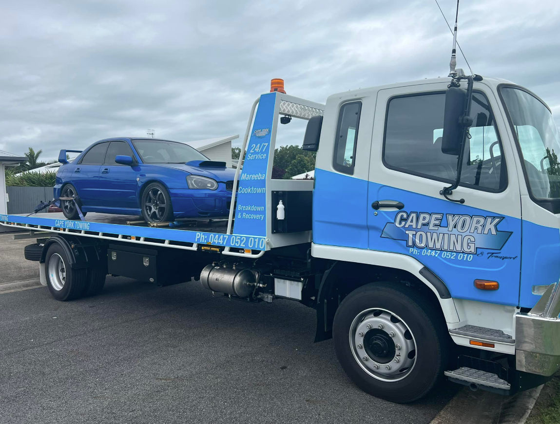 A Blue Car is Being Towed by a Tow Truck — Cape York Towing & Transport in Mareeba, QLD