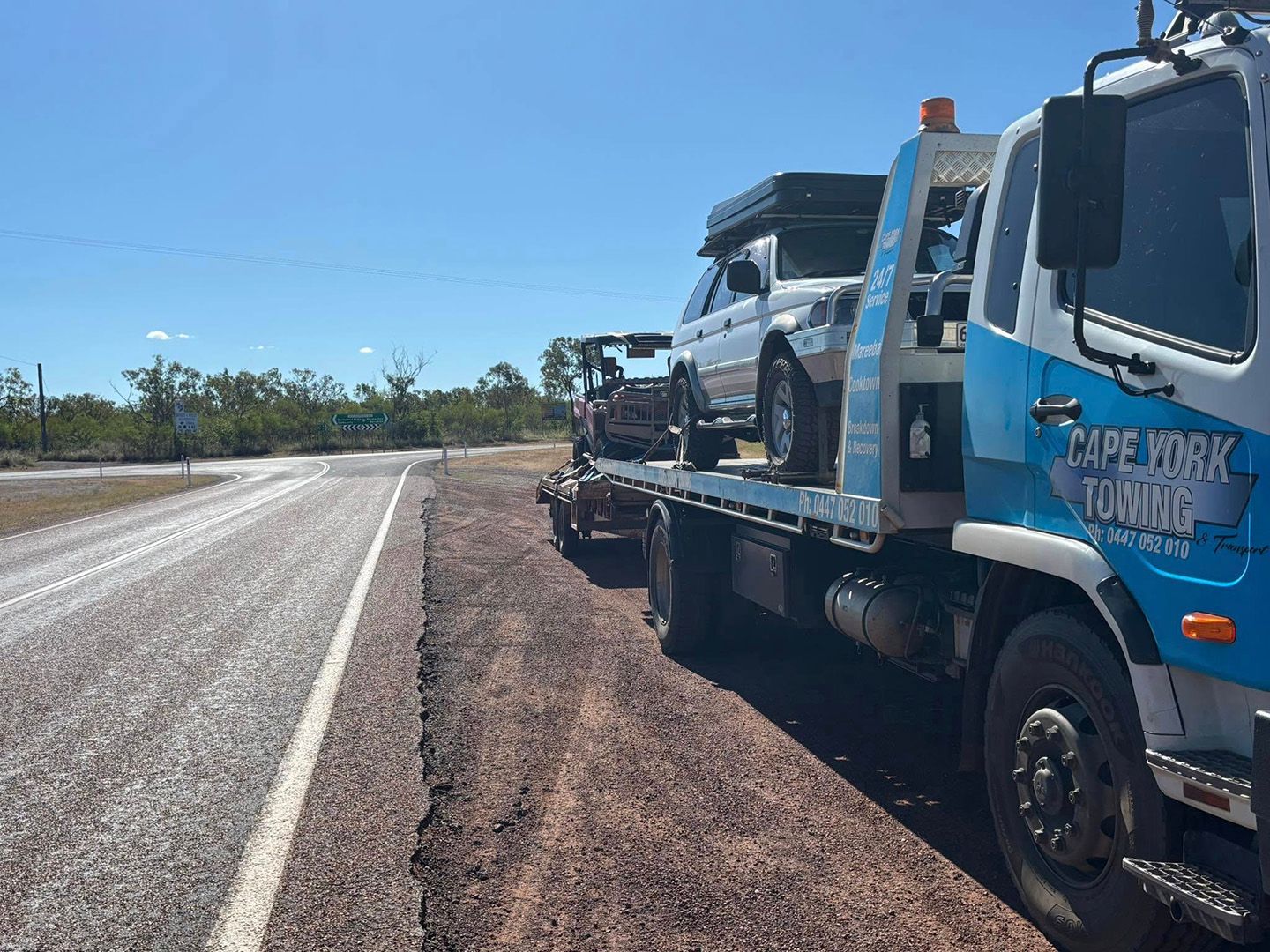 A Tow Truck In Mareeba Transporting A White SUV On A Highway