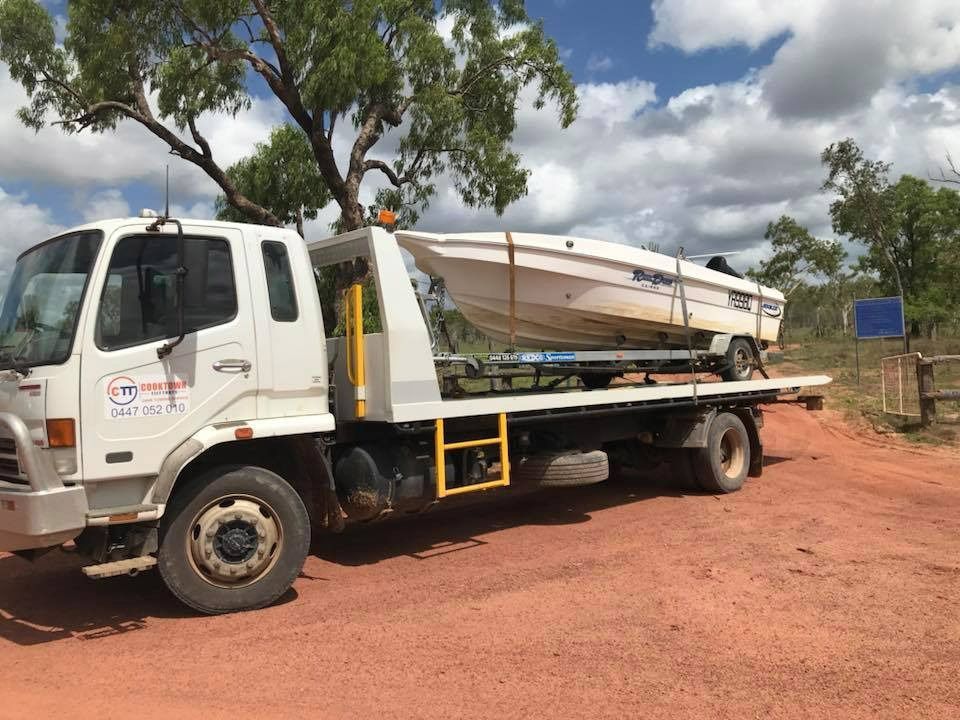 A Tow Truck is Carrying a Boat on the Back of It — Cape York Towing & Transport in Brisbane, QLD