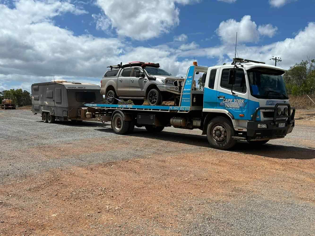 A Tow Truck is Carrying a Camper and a Truck — Cape York Towing & Transport in Croydon, QLD