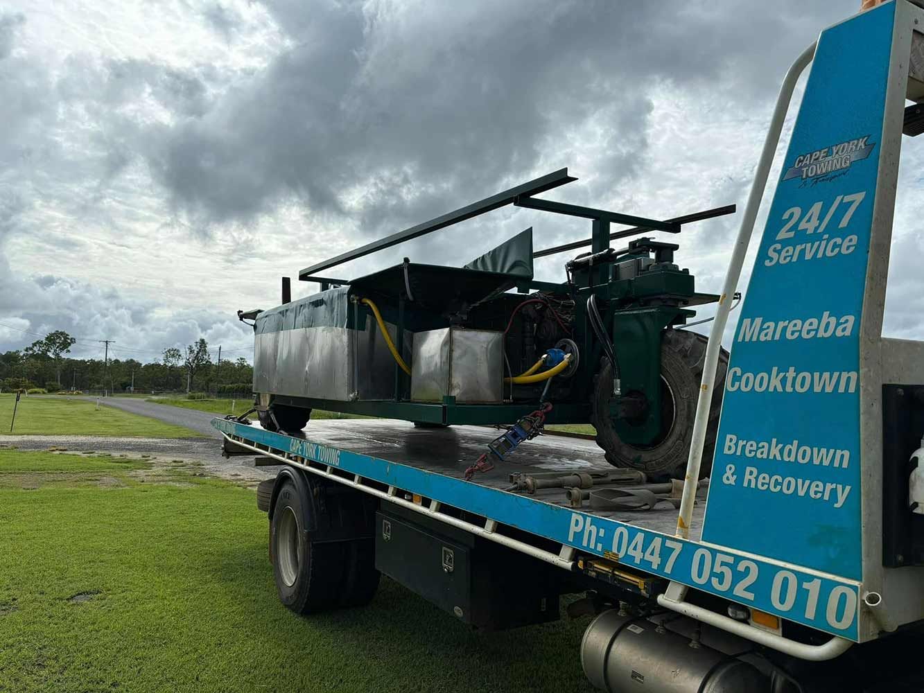 A Tow Truck With a Green Vehicle on the Back of It — Cape York Towing & Transport in Burketown, QLD