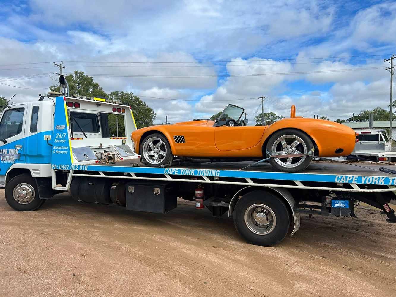 An Orange Sports Car is Being Towed by a Tow Truck — Cape York Towing & Transport in Adelaide, SA