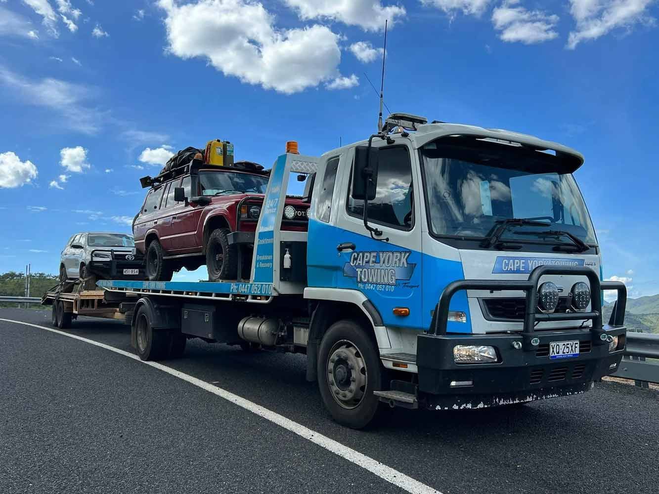 A Tow Truck is Carrying Two Cars on a Highway — Cape York Towing & Transport in Northern Peninsula Area, QLD