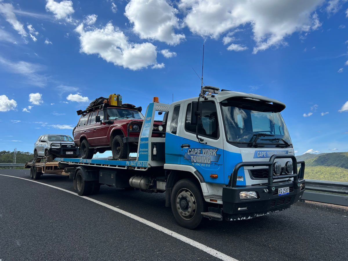 A Tow Truck is Carrying Two Cars on a Trailer — Cape York Towing & Transport in Mareeba, QLD