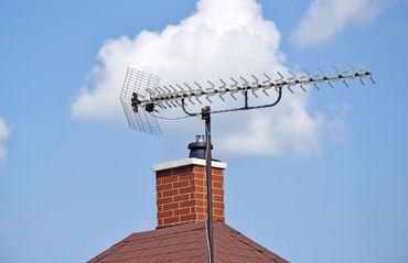 A brick chimney with an antenna on top of it