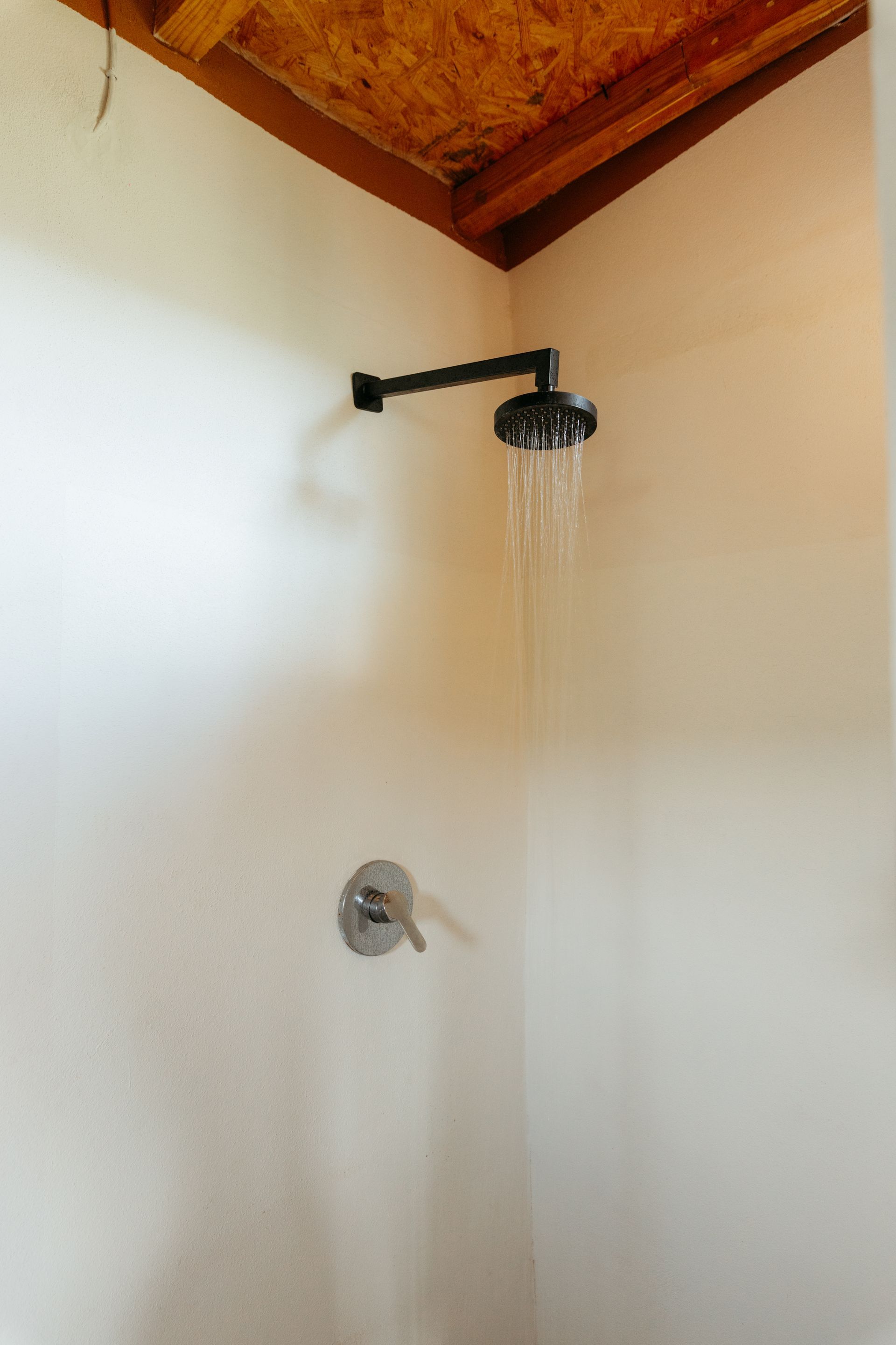 Cabezal de ducha negro con chorro de agua en posada del arquitecto en mazunte, oaxaca