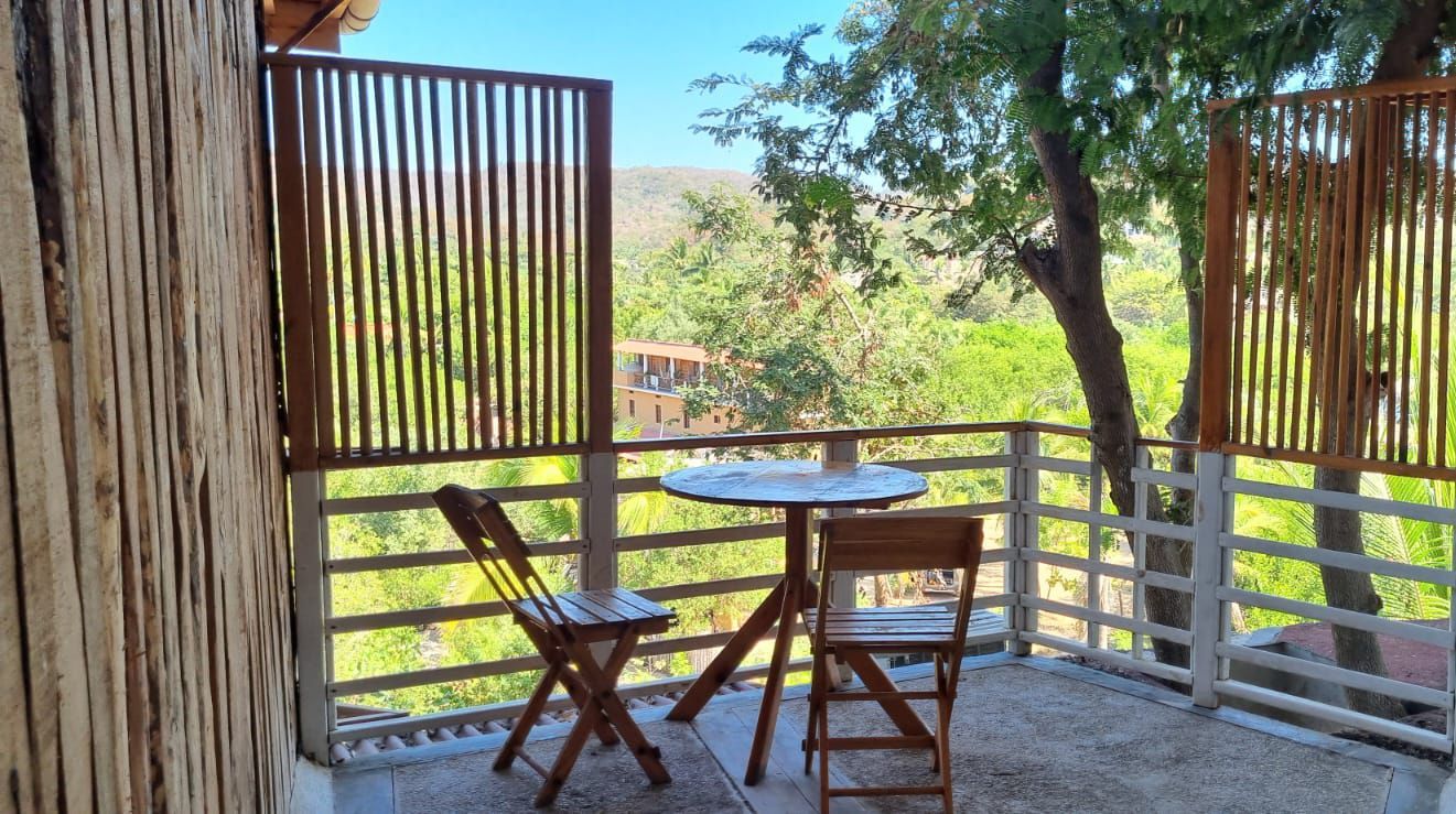 Balcón con vistas a un paisaje verde en posada del arquitecto en mazunte, oaxaca
