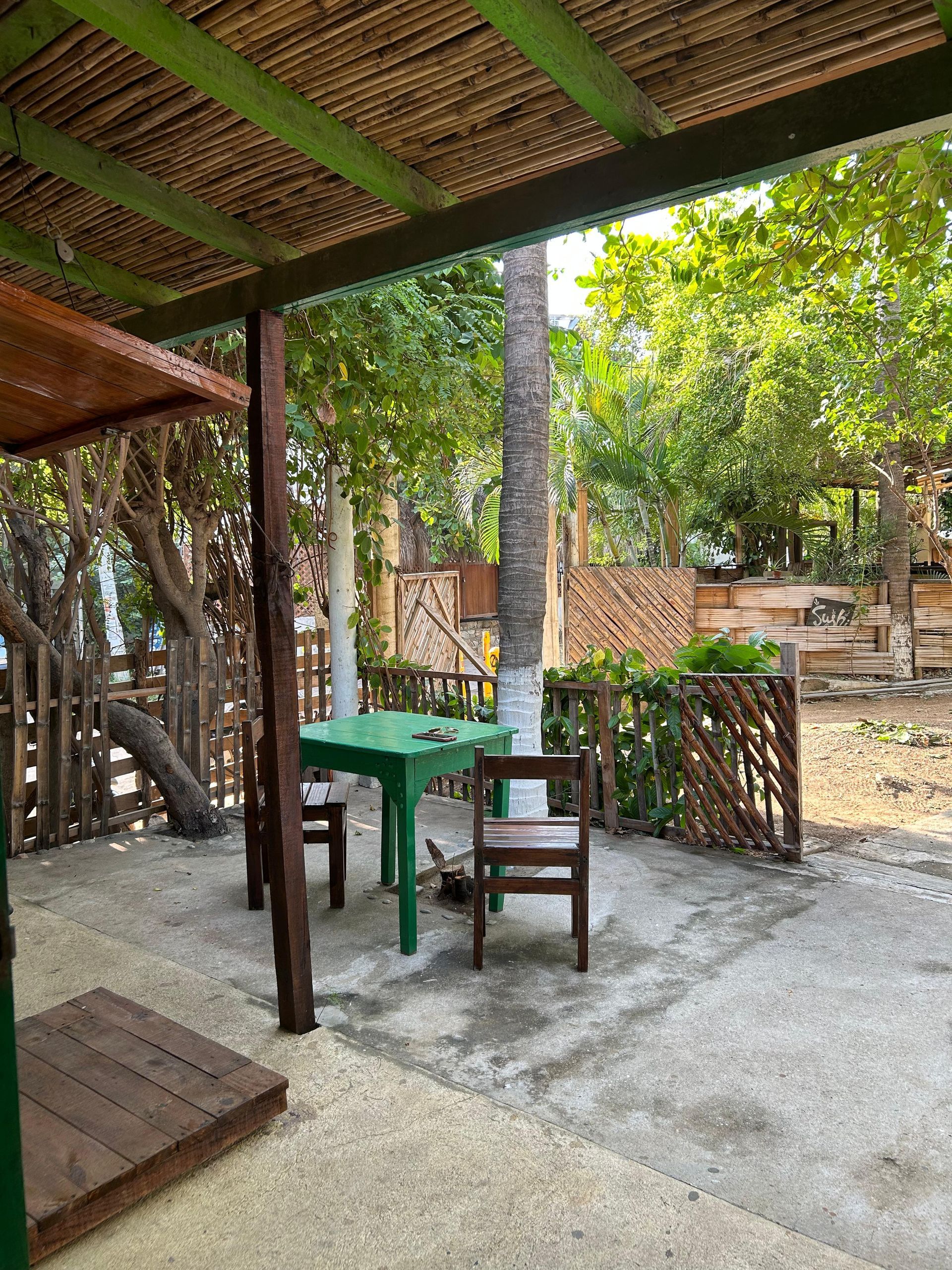 Patio exterior Rodeado de árboles y una valla de madera en posada del arquitecto en mazunte, oaxaca