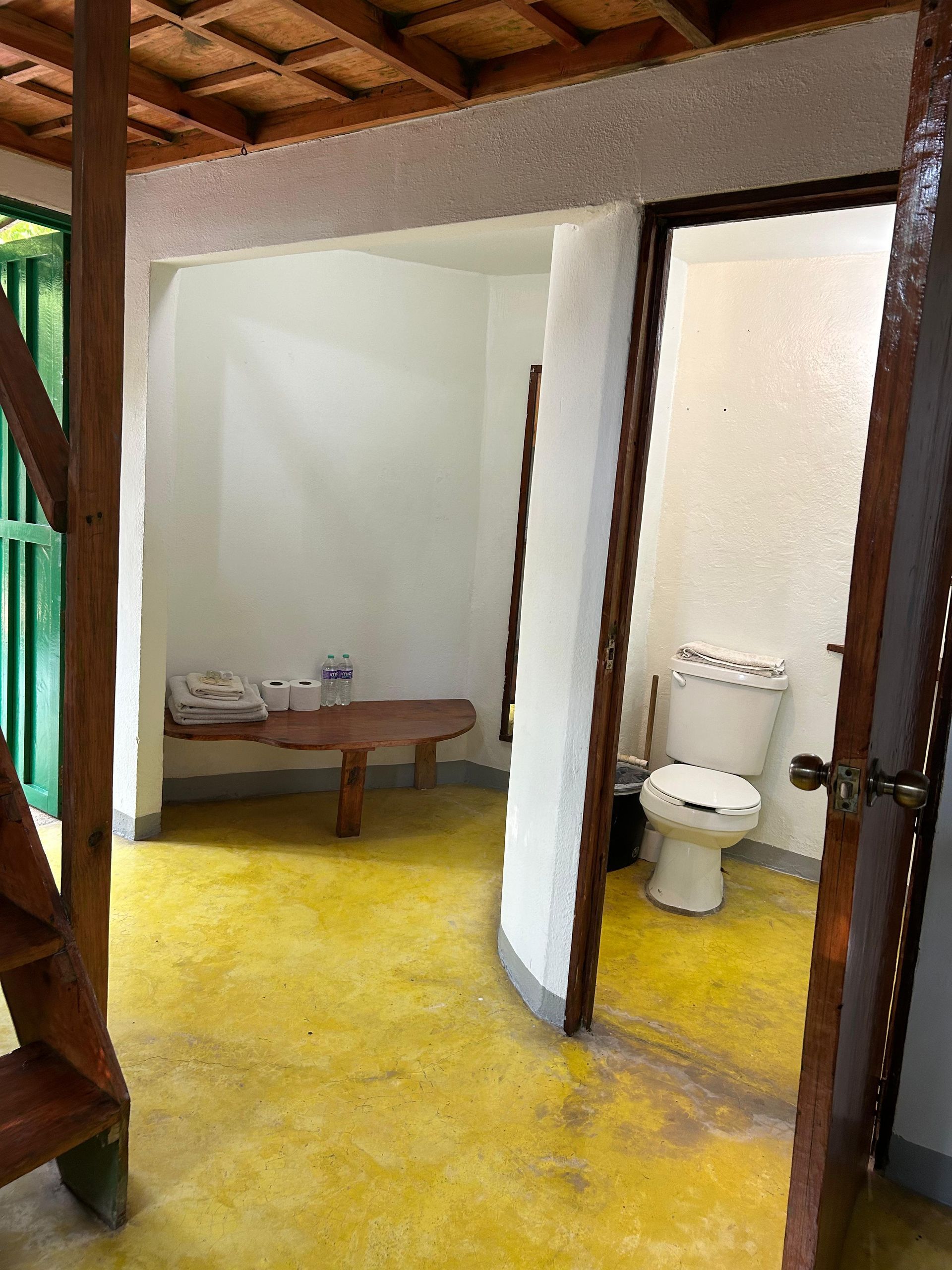 baño y pequeño banco de madera en posada del arquitecto en mazunte, oaxaca
