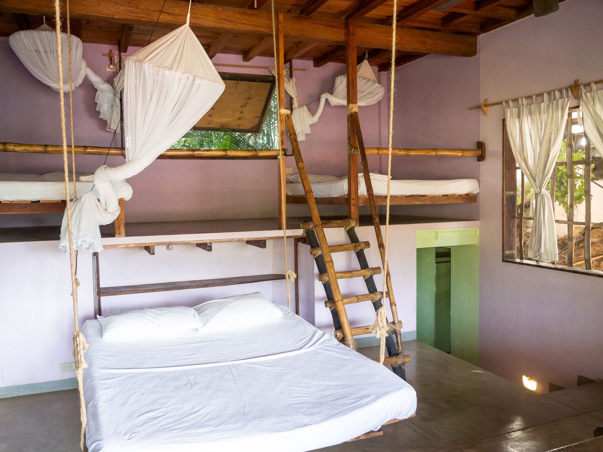 Dormitorio con camas tipo loft, cama colgante de cuerda, escalera de madera, mosquiteras y ventana en mazunte, oaxaca