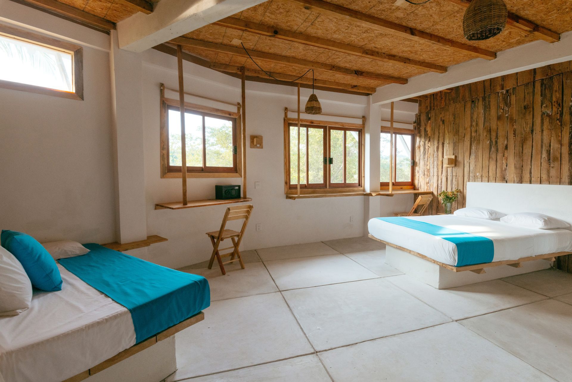 Habitación luminosa con paredes blancas, techo de bambú, ventanas y sofá en posada del arquitecto en mazunte, oaxaca