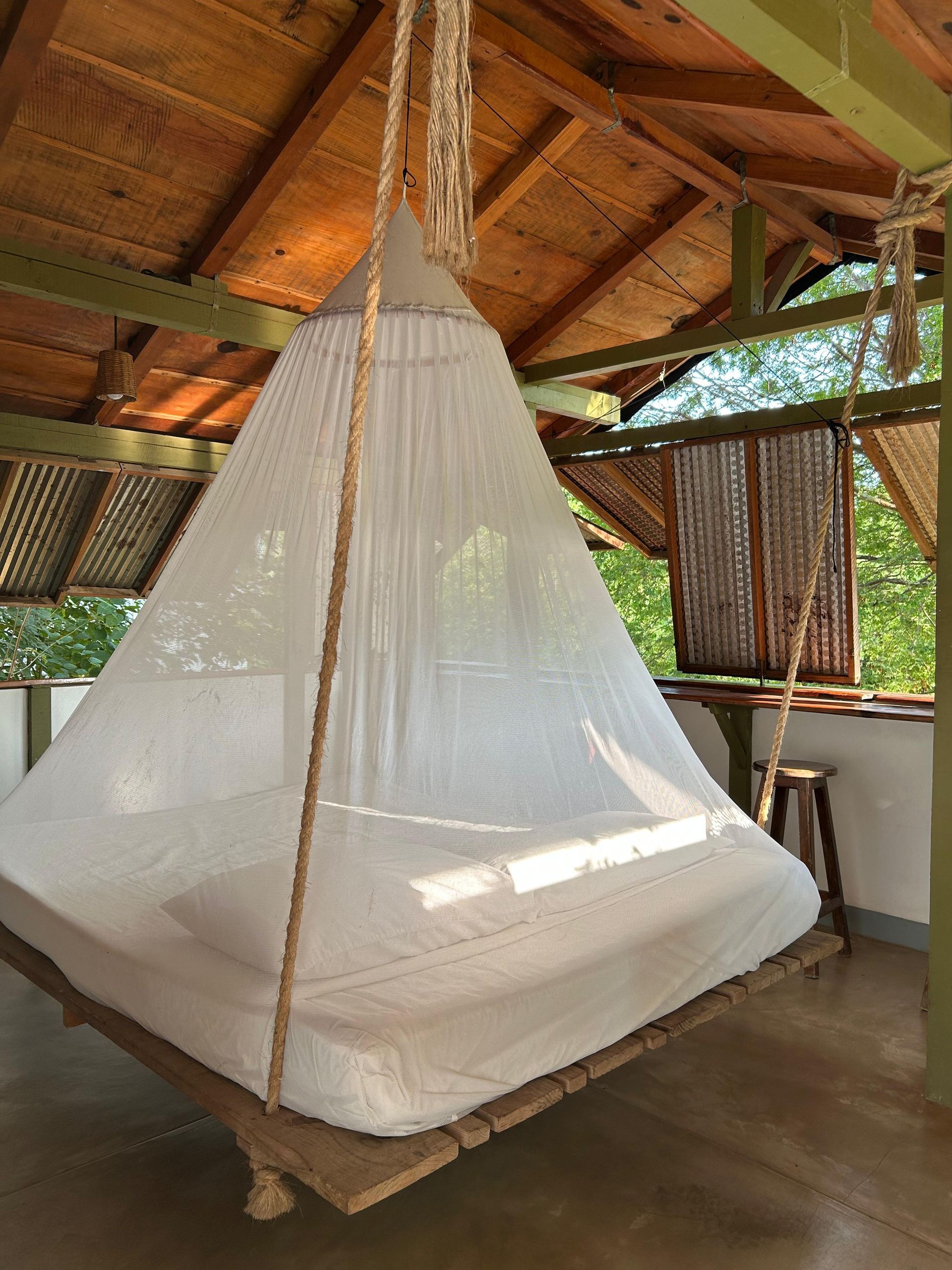 Una cama suspendida por cuerdas en posada del arquitecto en mazunte, oaxaca