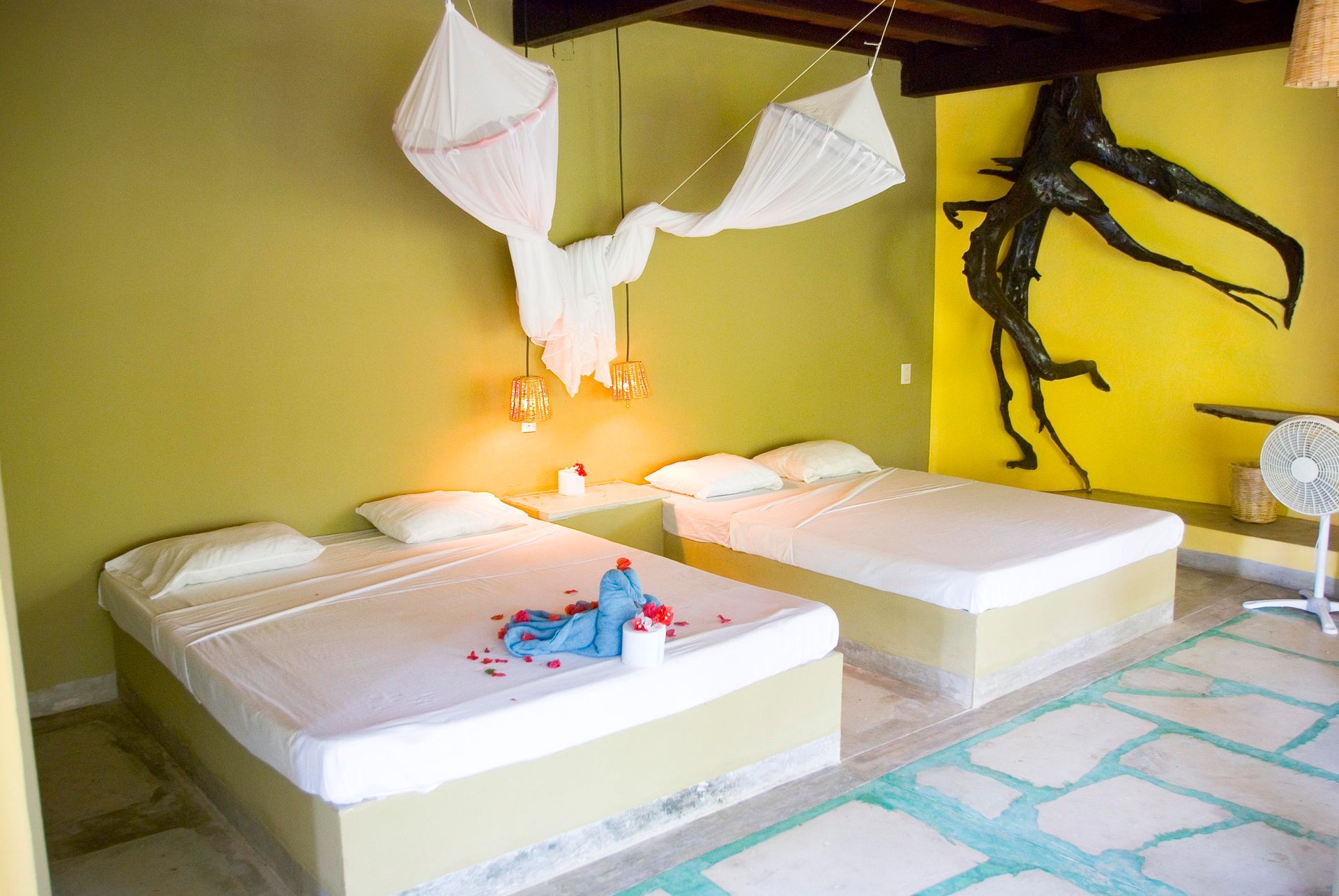 Dos camas en una habitación con ventilador en posada del arquitecto en mazunte, oaxaca