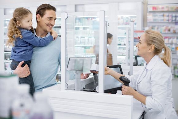 father purchasing prescription for his young daughter