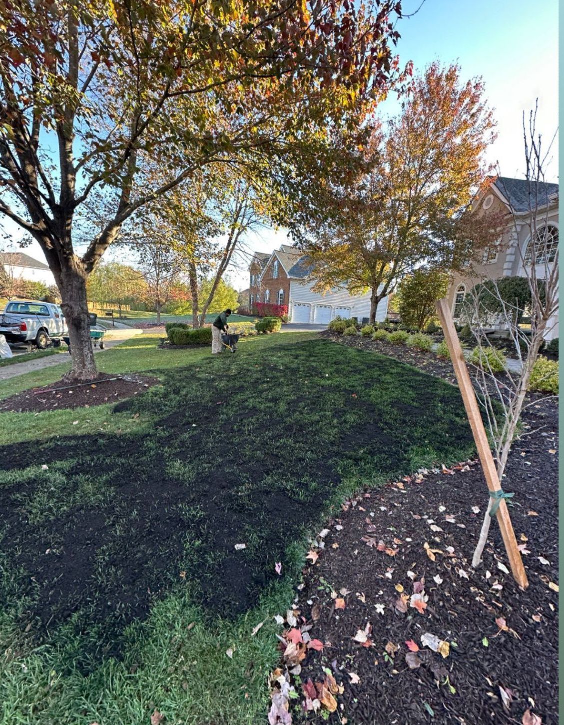 A large pile of mulch is sitting in the middle of a lush green field.