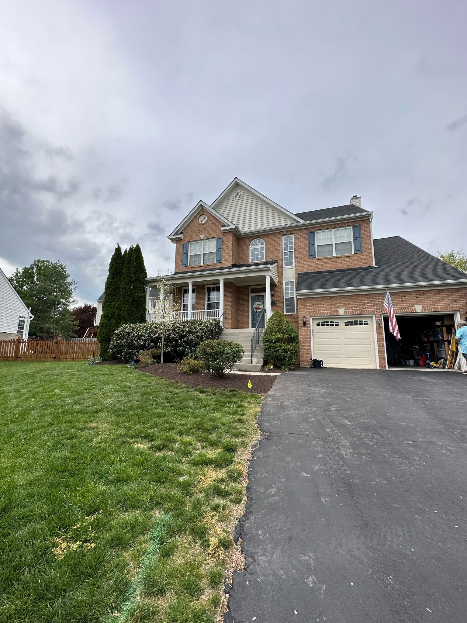 A large brick house is sitting on top of a lush green hillside.